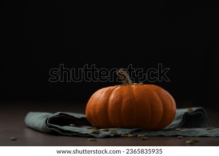 Orange pumpkin on linen napkin on wood table for seasonal background