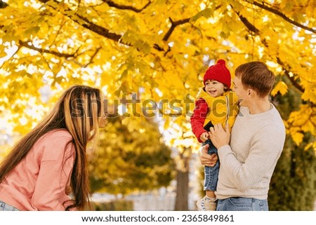 an mixed family with their child in the autumn park spent time together. Warm feelings and emotions Royalty-Free Stock Photo #2365849861