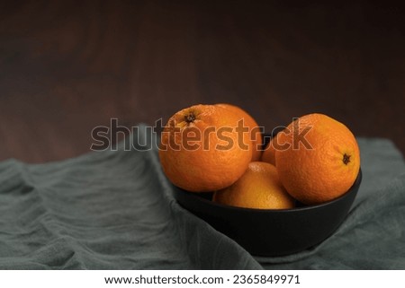 Fresh tangerines in a bowl on a wood table