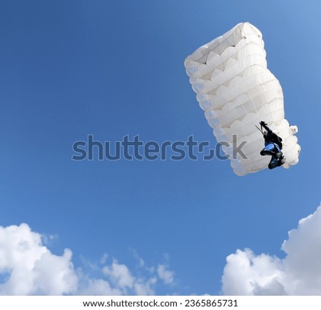 parachutist with white parachute on blue sky extreme sport Royalty-Free Stock Photo #2365865731