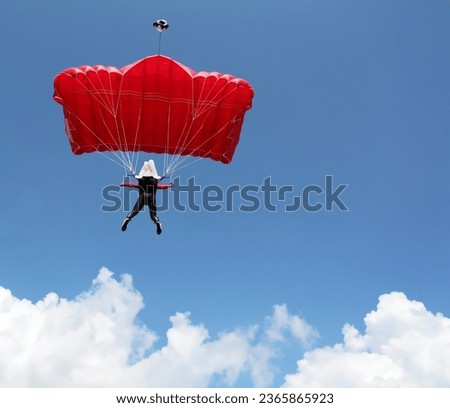 parachutist with red parachute on blue sky extreme sport Royalty-Free Stock Photo #2365865923