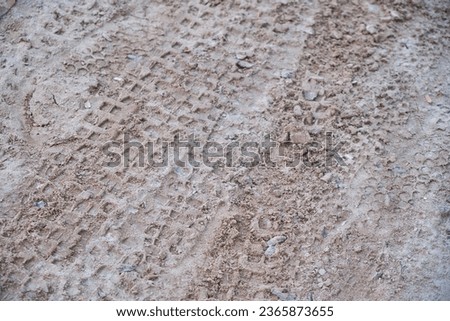 Tracks from the wheels of a bicycle on a dirt road made of sand. View from above. Close-up