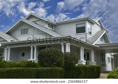VARIOUS GABLED ROOFLINE PERIOD CHARACTER HOUSE Multi levels with a large corner patio porch verandah with thick columns on a white wooden timber siding style home, decorative trims and hedged garden