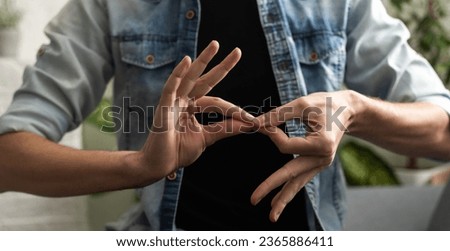 Sign language interpreter man translating a meeting to ASL, American Sign Language. Empty copy space for Editor's content