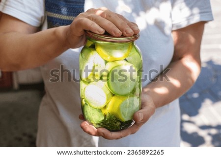 A woman is holding a jar of pickled zucchini. Home canned healthy vegetable food. Female hands hold a glass jar with canned zucchini.
Homemade canned vegetables. Food.