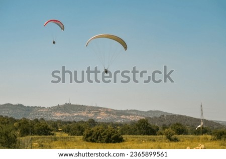 Two paratroopers jumping from a parachute center located north of Mersin city center and the Taurus mountains in the background. Royalty-Free Stock Photo #2365899561