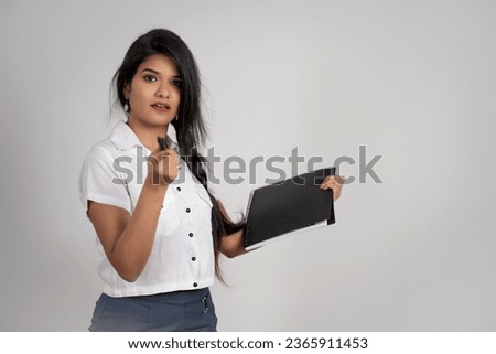 Young indian businesswoman or employee standing with book on white background