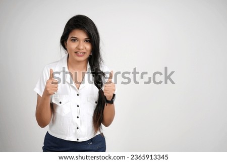 Smiling young indian woman showing both hand thumbs up on white background
