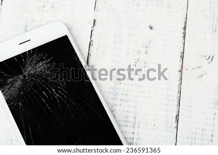Broken iPhone on wooden background