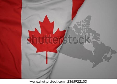 big waving national colorful flag and map of canada on the gray background. macro Royalty-Free Stock Photo #2365922103