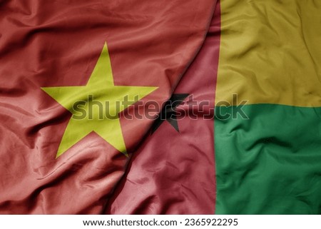 big waving realistic national colorful flag of vietnam and national flag of guinea bissau . macro