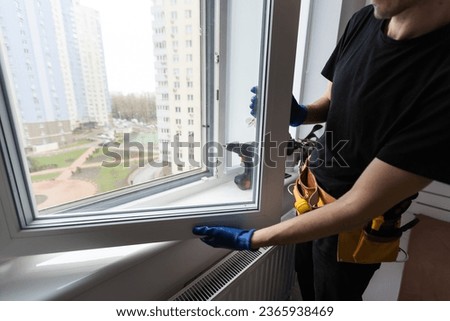Handsome young man installing bay window in a new house construction site