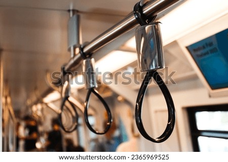 Handle strap and bar inside the Skytrain. increase safety for standing passengers. Handle strap with blur background. Royalty-Free Stock Photo #2365969525