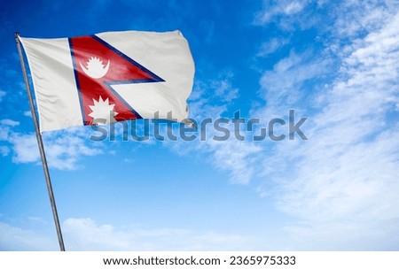 Nepal Flag - The distinctive flag of Nepal waving gracefully. This flag is unique in its design, featuring two stacked triangles – one representing the sun and the other the moon