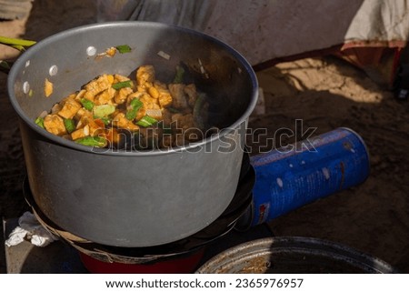 Man cooking vegetable when camping summer. The photo is suitable to use for adventure content media, cooking poster and outdoor activity background.