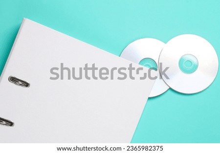 CD's with a folder on a blue background. Business concept