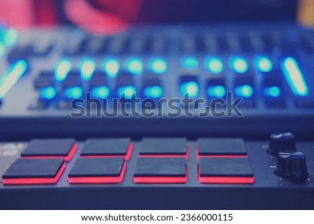 DJ mixer in nightclub with blue and red lights. Close up.