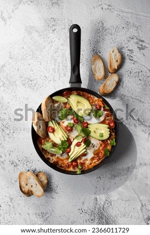 Shakshuka in an iron pan. Middle eastern traditional dish in Mexican style.  Royalty-Free Stock Photo #2366011729