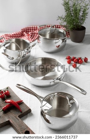 Set of stainless pots with lids and vegetables Royalty-Free Stock Photo #2366011737
