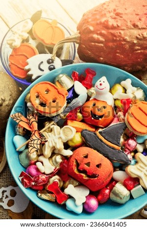 Halloween Jack o Lantern candy bowl with candy, sweets and halloween cookies Trick or Treat holidays background