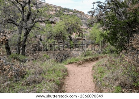 A nature trail leading through the tranquil landscape of the Texas Hill Country located in the Enchanted Rock State Park, Texas Royalty-Free Stock Photo #2366090349
