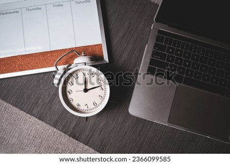 The top view of the clock and computer for time management of work and balance life.