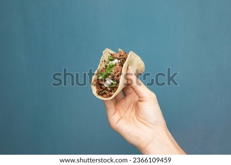 Taco held up in the air Royalty-Free Stock Photo #2366109459