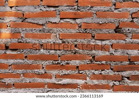 a photography of a brick wall with a red brick in the middle, stone wall with red bricks and cement blocks in a brick wall.