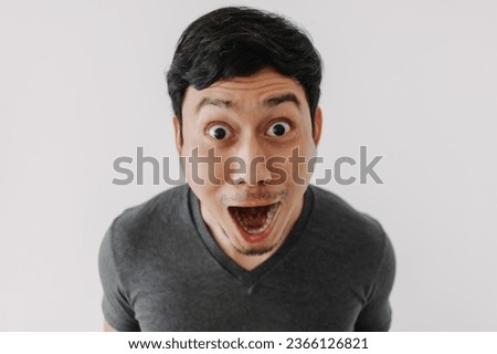 Funny surprised shocked asian man face for promotion isolated on background.