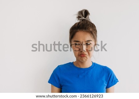 Unsatisfied grumpy asian woman isolated on white. Royalty-Free Stock Photo #2366126923