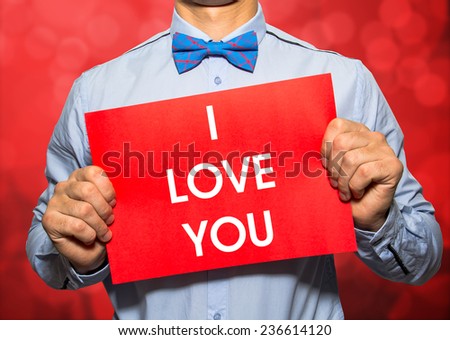 Businessman on red bokeh background with the text I love you in a concept image