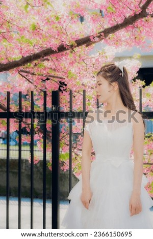 Young girl wearing bridal wedding dress taking pictures enjoying happiness alone.