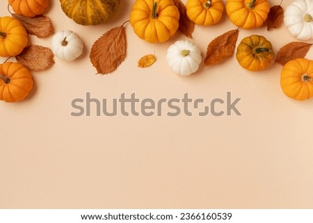 Happy Thanksgiving holiday background from dried autumn foliage and decorative pumpkins top view. Harvest, halloween, autumn and fall composition.
