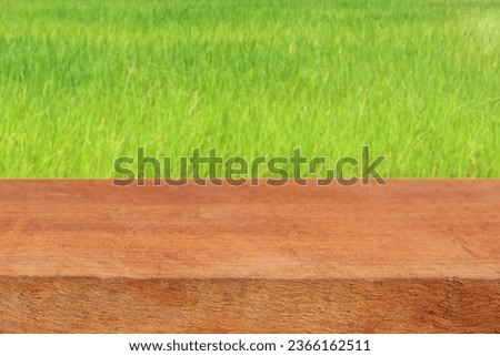 Wooden table with blurred grass background for product display concept. 
