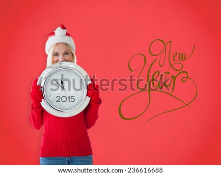 Happy festive blonde with clock against red background