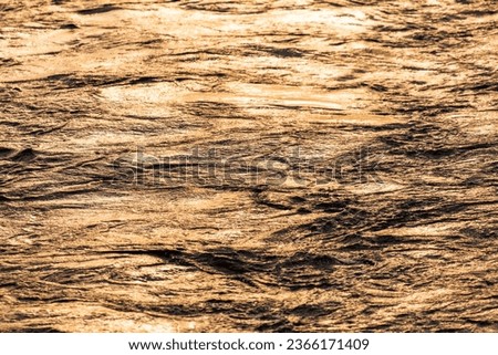 The surface of the water in the river at sunset.