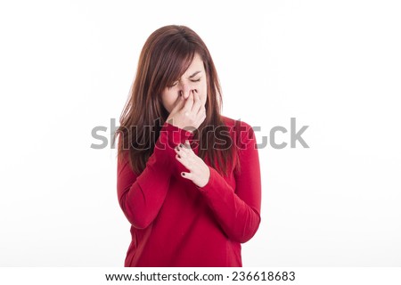 Young girl holding her nose smelling something stinking moving her hand Royalty-Free Stock Photo #236618683