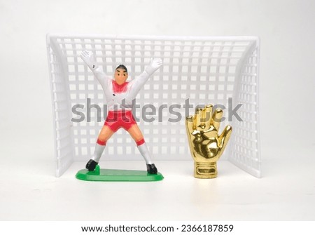 A picture of Golden Glove trophy with miniature goalpost insight.