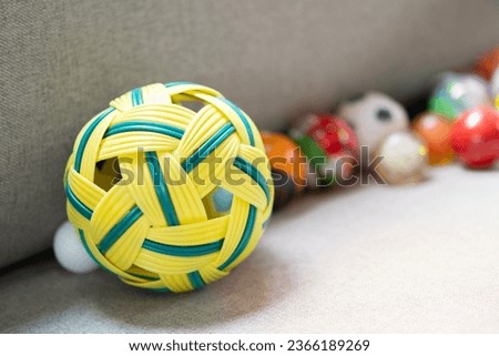 Close up of old takraw ball or rattan ball asia nearby are many more toy balls on the sofa. Kids game concept.