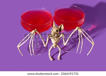 Bat skeleton with glasses of tasty cocktail for Halloween celebration on purple background