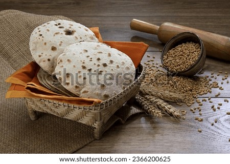 Pakistan and Indian Chapati  Fulka or Gehu Roti with wheat grains in background. It's a Healthy fiber rich traditional North, South Indian food Royalty-Free Stock Photo #2366200625
