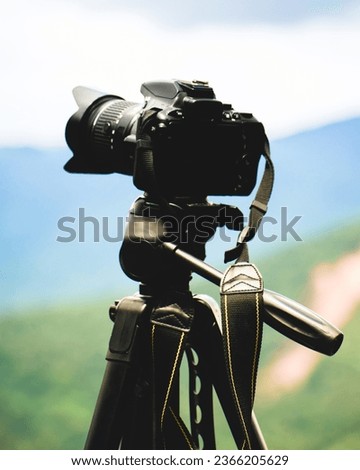 Professional camera on the tripod on the background of the mountain landscape.