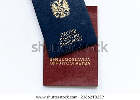 A Serbian passport on top of a passport of the former Yugoslavia isolated in white. Royalty-Free Stock Photo #2366218259