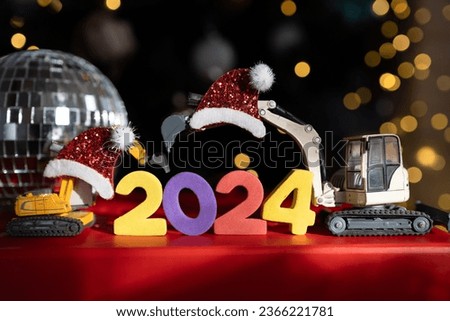 Christmas holidays, festive mood. multi-colored numbers 2024, toy excavator models, mirror disco ball, bokeh. Happy New Year business greeting concept for construction companies