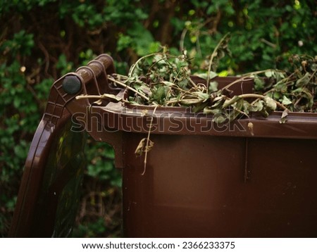 Brown wheelie bin for garden waste medium shot selective focus Royalty-Free Stock Photo #2366233375