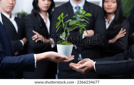 Eco-friendly investment on reforestation by group of business people holding plant together in office promoting CO2 reduction and natural preservation to save Earth with sustainable future. Quaint Royalty-Free Stock Photo #2366234677