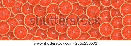 Top view of many red grapefruit slices as a background image. A saturated citrus pattern. Flat lay