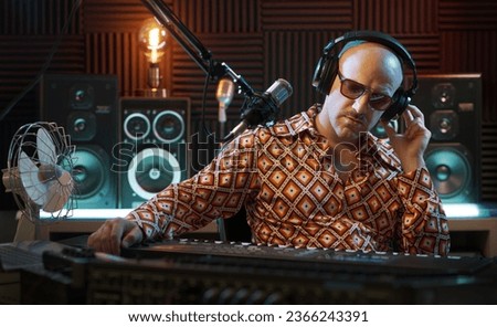 Professional musician working in the recording studio, he is playing the keyboard and recording a song
