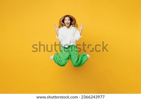 Full body young shocked surpised caucasian happy woman she wears white shirt casual clothes jump high look camera spread hands isolated on plain yellow background studio portrait. Lifestyle concept Royalty-Free Stock Photo #2366243977