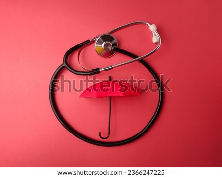 Top view stethoscope and red umbrella on a red background